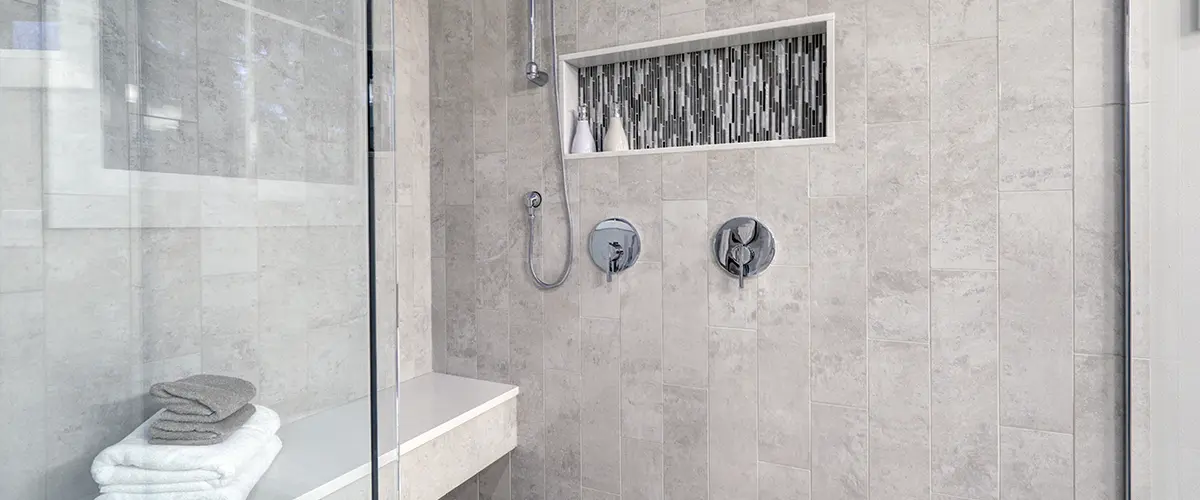 Modern shower with sleek bathroom walls and neatly folded towels.