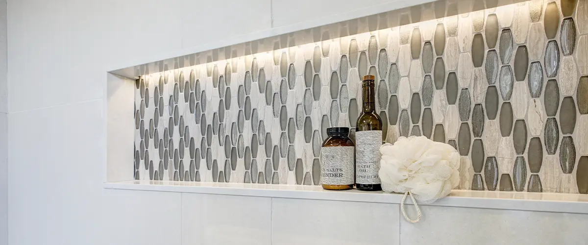 Stunning walk-in shower with white tile surround and niche.