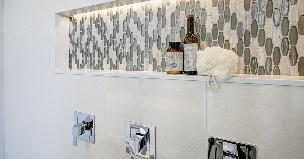 Stunning walk-in shower with white tile surround and niche.