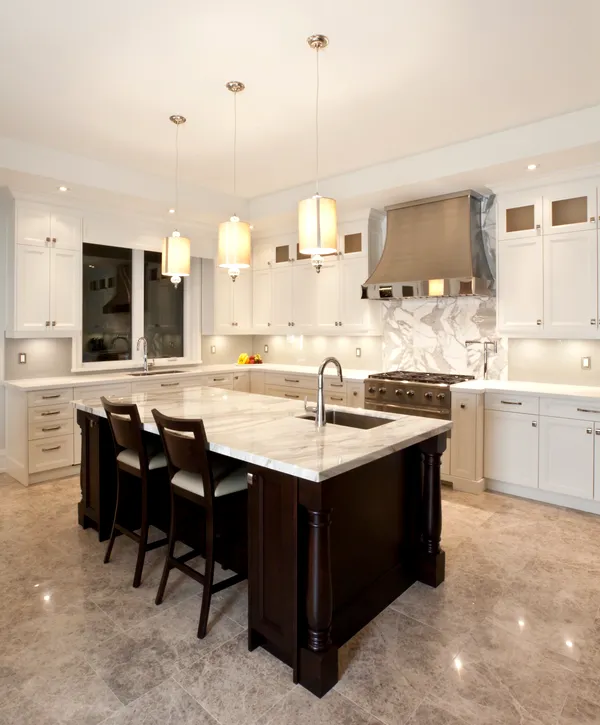 Elegant kitchen with marble countertops and dark wood island.