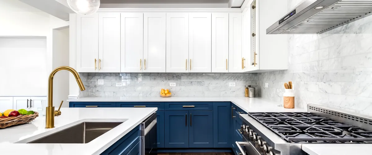 Navy blue and white kitchen with gold accents and a large island