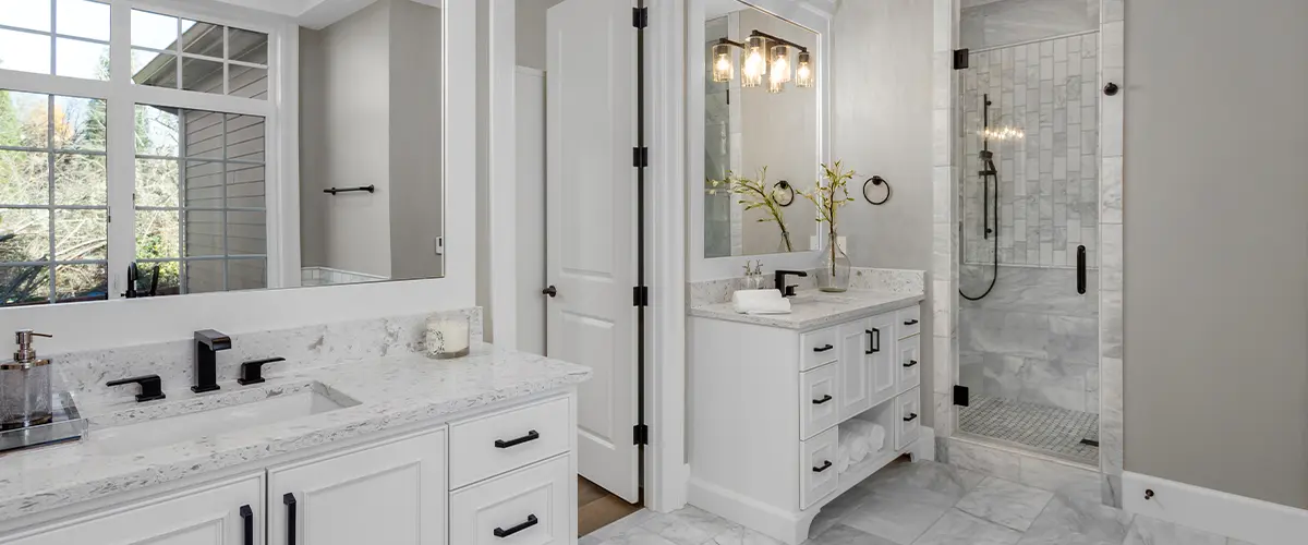 Spacious luxury bathroom with dual vanities, glass-enclosed shower, and marble countertops in a modern design.