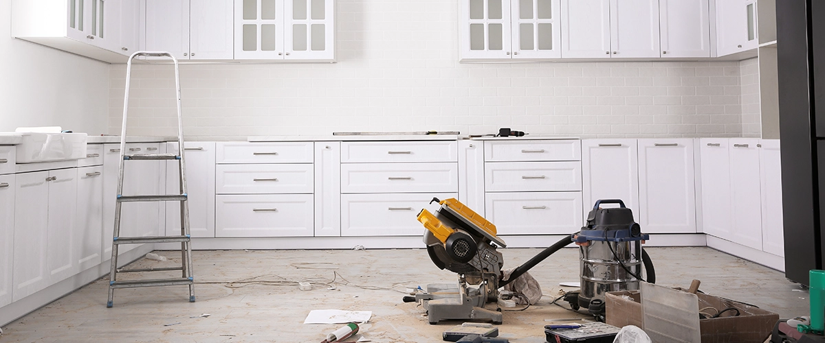 A kitchen under renovation with tools scattered across the floor, partially installed cabinets by Kitchen Remodeling Company in Neuse Township